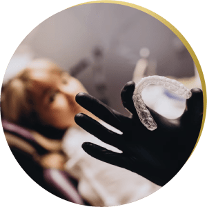 Dentist holding a clear aligner in focus – Custom dental solutions, including inlays & onlays, for a perfect smile.