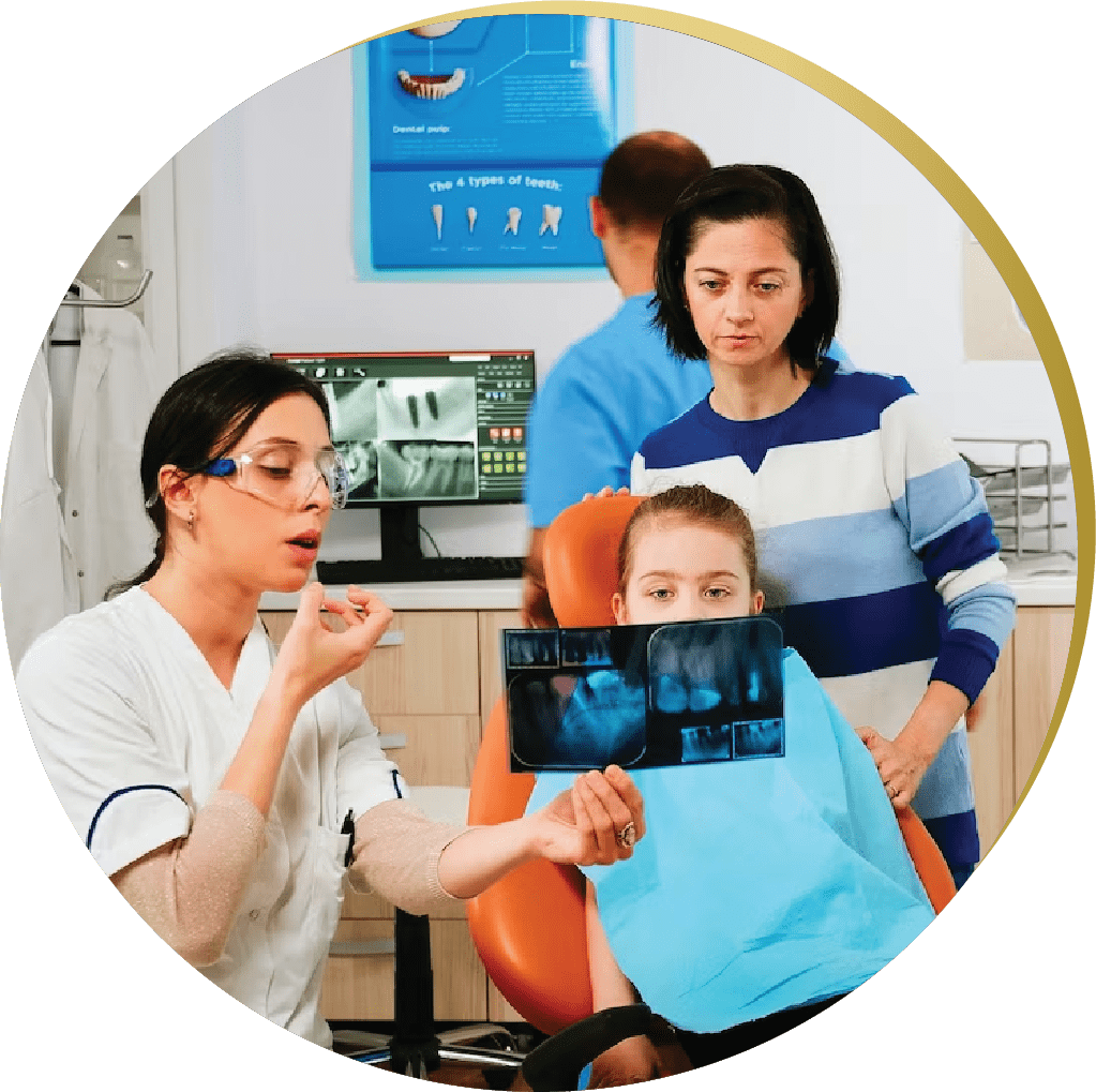 A female dentist shows a dental model to a young girl and her mother during a consultation in a family-friendly dental office. General and Family Dentistry.