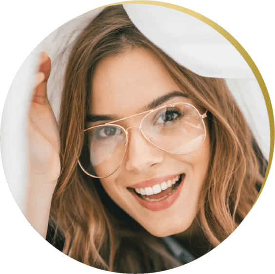 A woman smiling, wearing glasses, with a bright, confident smile, in a cheerful indoor environment, highlighting cosmetic dentistry in Las Vegas