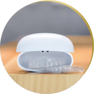 A white clear aligner storage case slightly open, revealing clear aligners inside, placed on a wooden surface.