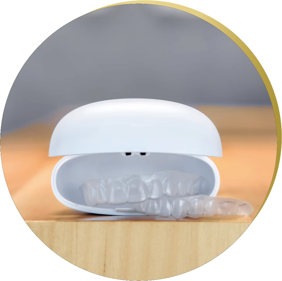 A white clear aligner storage case slightly open, revealing clear aligners inside, placed on a wooden surface.